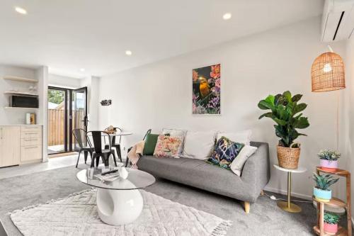 a living room with a couch and a table at Vibrant 2 bed Henderson Abode in Auckland
