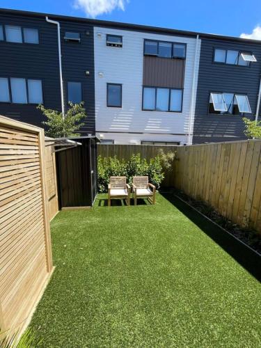 a backyard with a fence and a table and chairs at Stylish 1 Bed 1 Bath Retreat in Auckland