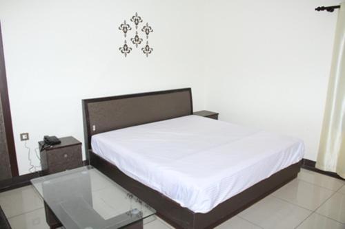a bed in a room with a glass table at Hotel Sukoon in Dehradun