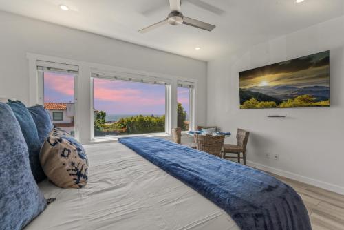 a bedroom with a large bed with blue pillows at Ocean VIEWS Steps from Victoria Beach Lux Design in Laguna Beach