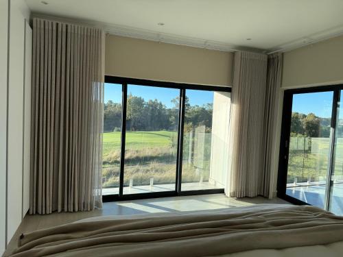 a bedroom with a large window with a view of a golf course at Villa 374 Vaal De Grace in Grooteiland