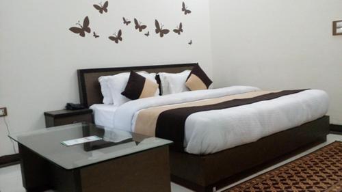 a bedroom with two beds with birds on the wall at Hotel Sukoon in Dehradun