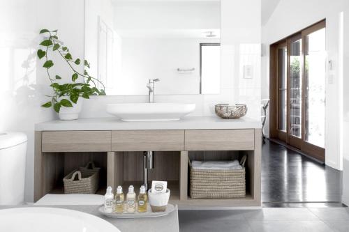 a bathroom with a sink and a mirror at Tranquil Byron Bay Villa, Hinterland views - Vue 5 in Ewingsdale