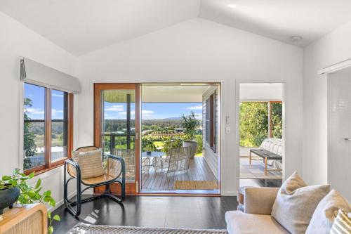 a living room with a couch and a balcony at Tranquil Byron Bay Villa, Hinterland views - Vue 5 in Ewingsdale