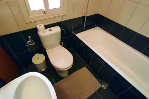 a bathroom with a toilet and a tub and a sink at Bungalow Sea Paradise - Beachfront Escape with Sea View in Polis Chrysochous