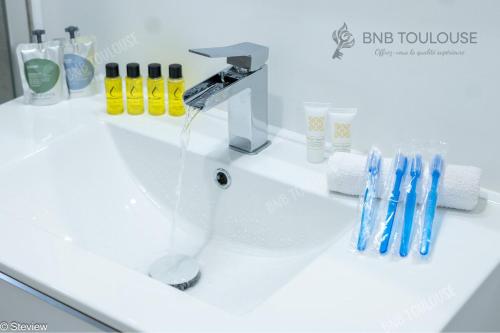 - un lavabo avec un robinet et des brosses à dents dans l'établissement BNB TOULOUSE - Refuge urbain - Clim - Terrasse - Parking - WiFi - Proche transports, à Toulouse