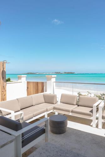 a living room with white furniture and the beach at 4 Bedroom Cable Beach Condo with Balcony in Nassau