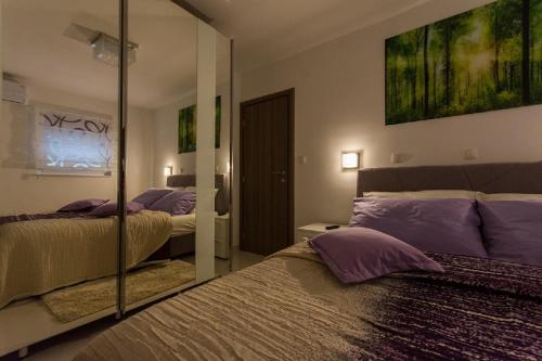 a bedroom with two beds and a mirror at Agava Lux in Trogir