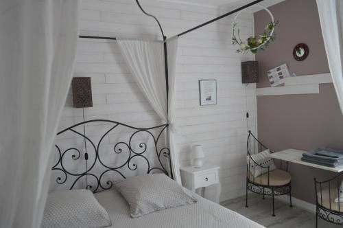 une chambre avec un lit, un bureau et une chaise dans l'établissement Au Coeur Du Bien Etre, chambre d'hôtes avec piscine chauffée et couverte, SPA, sauna, massages, à Monteaux