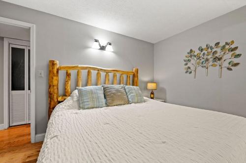 a bedroom with a large bed with a wooden headboard at Windy Oaks Condo by Avada Properties in Gatlinburg