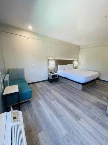a hotel room with a bed and a chair at Sonesta Essential North Houston in Houston