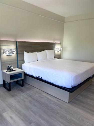 a bedroom with a large bed and a table at Sonesta Essential North Houston in Houston