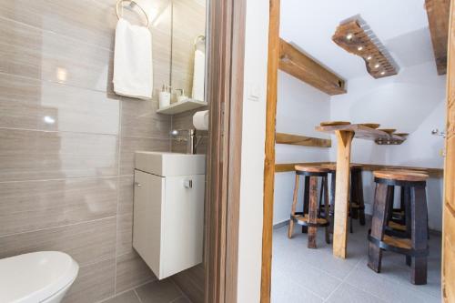 a bathroom with a toilet and a sink and a table at Agava Lux in Trogir