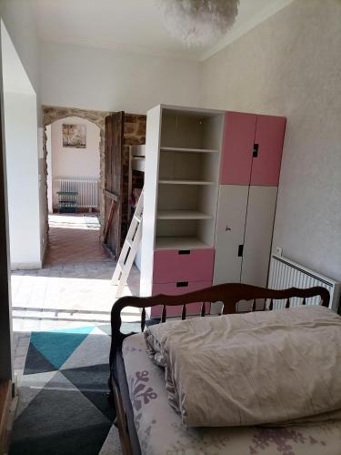 a bedroom with a bed and a pink cabinet at Edelweiss in Roussillon-en-Morvan