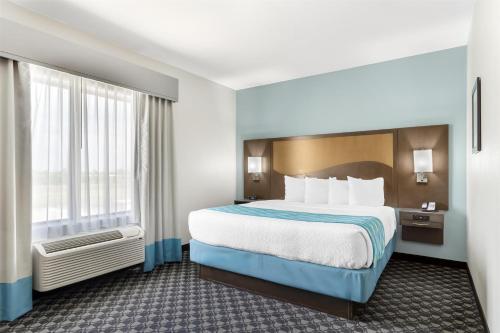 a hotel room with a bed and a large window at Best Western Plus Waller Hotel in Waller