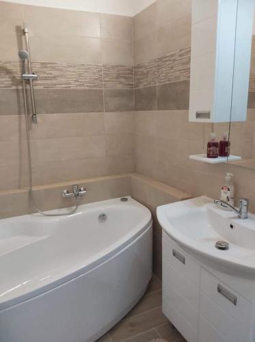 a bathroom with a white tub and a sink at Ancsi-Lak Tapolca in Tapolca