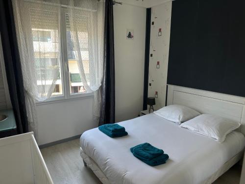 una camera da letto con un letto con due asciugamani sopra di Maison familiale à Morgat, jardin clos, à 2 minutes de la plage a Crozon