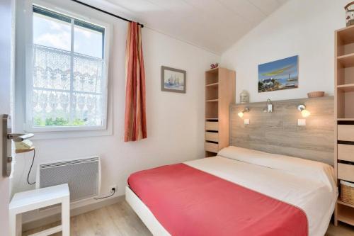 - une chambre avec un lit rouge et blanc et une fenêtre dans l'établissement Résidence Port Bourgenay - maeva Home - Appartement 2 pièces + mezzanine 4 personnes - Prestige MAE-8961, à Saint-Hilaire-de-Talmont