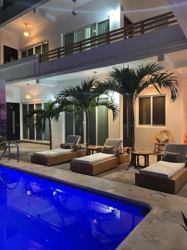 a swimming pool with two beds and a house at Casa Arizona in Brisas de Zicatela