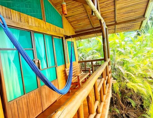 a porch of a house with a hammock on it at Ocean Forest Ecolodge in San Pedrillo
