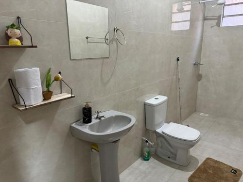 a bathroom with a white toilet and a sink at Casa Em Goiânia - Bairro Capuava in Goiânia