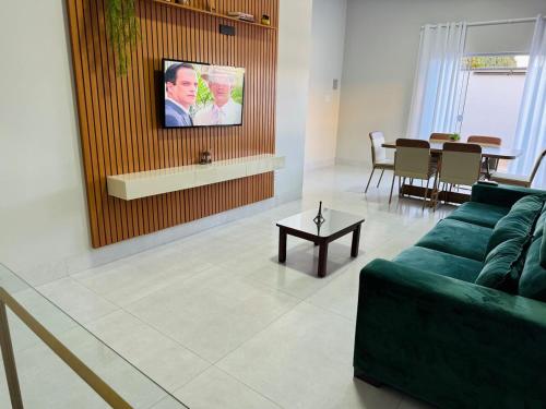 a living room with a green couch and a table at Casa Em Goiânia - Bairro Capuava in Goiânia