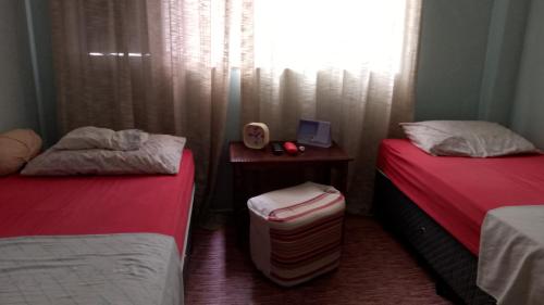 a room with two beds and a window at Espaço DéboraMa&Deise in Rio de Janeiro