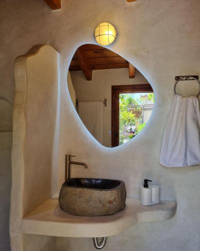 a bathroom with a stone sink and a mirror at Fay's Guesthouse Aegina in Egina