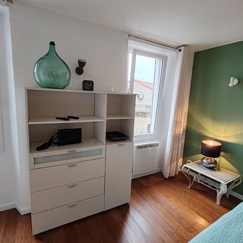 une étagère blanche avec un vase dans une pièce dans l'établissement appart centre historique Picasso, à Vallauris