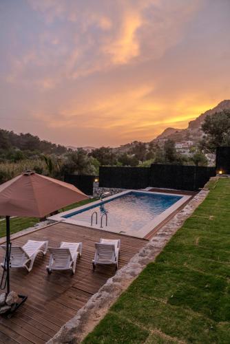 a swimming pool with two chairs and an umbrella at Villa Lotus in Sogut
