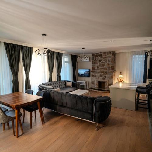 a living room with a black couch and a table at Villa Lotus in Sogut