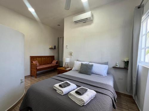a bedroom with a large bed with towels on it at Coco apartamento centrico in Cozumel