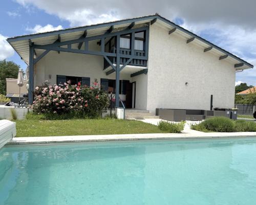 a house with a swimming pool in front of a house at Villa Spa du Bassin - Le Teich - Bassin d'Arcachon in Le Teich
