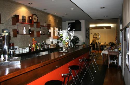 um bar num restaurante com balcão e bancos em Hotel Viento del Norte em Porto de Espasante
