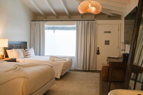 a hotel room with two beds and a window at The Montauk Beach House in Montauk