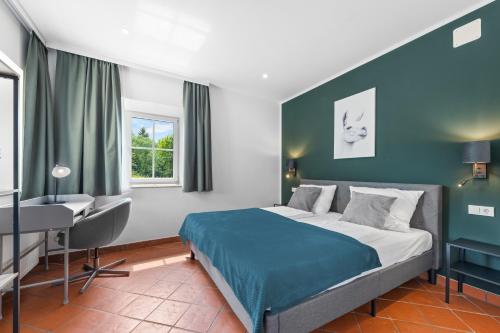 a bedroom with a bed and a desk and window at NA-Home Melcherhof in Grafenstein