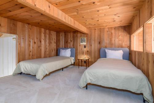 two beds in a room with wooden walls at Incredible Sea Ranch Escape for 6 With Ocean Trail in Sea Ranch