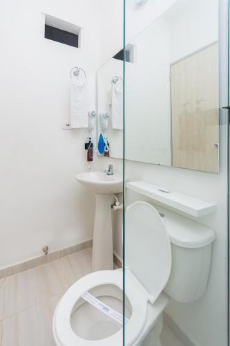 a bathroom with a toilet and a sink at Hotel Suite del Parque in Medellín