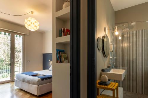 a bedroom with a bed and a sink and a mirror at Cosy in the Park in Como