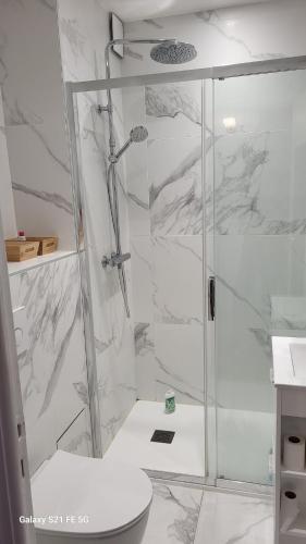 une douche avec une porte vitrée dans une salle de bain dans l'établissement Joli studio 2 pas du port, clim et au calme, à Bandol