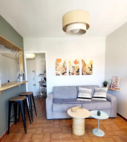 un salon avec un canapé bleu et une table dans l'établissement Joli studio 2 pas du port, clim et au calme, à Bandol