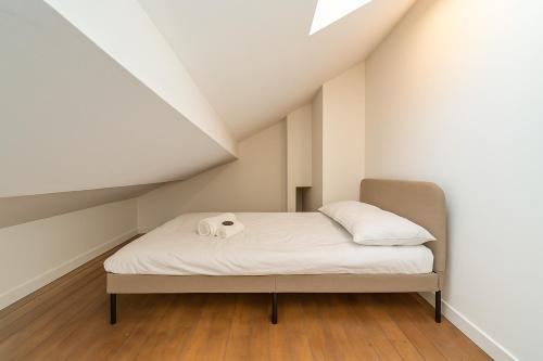 une petite chambre avec un lit dans un grenier dans l'établissement Studio Navarre Calm and comfort at La Mulatière, à La Mulatière