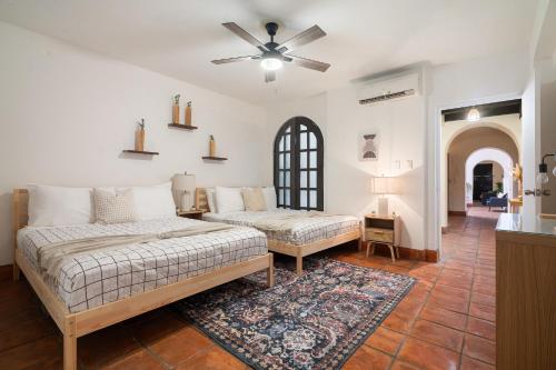 a bedroom with two beds and a ceiling fan at Fountain Historic Villa Old San Juan by PH in San Juan