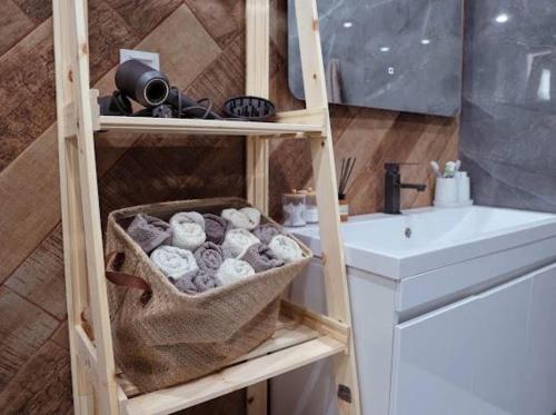 - une salle de bains avec une étagère en bois à côté d'un lavabo dans l'établissement Дом в Дилижане, à Dilidjan