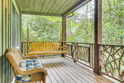 a porch with a bench and a chair on a deck at 1 Mi to Downtown Cashiers Private Cabin with Deck in Cashiers