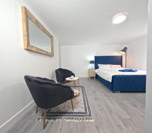 a bedroom with a bed and a chair and a mirror at The Big Gun Guest House in Midland