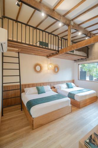 two beds in a bedroom with a loft at Candelaria Aparta Hotel Boutique in Medellín
