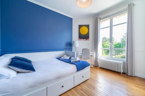 a blue bedroom with a bed with blue walls and a window at La Belle Adresse Chic, Calme & Spacieuse in Versailles
