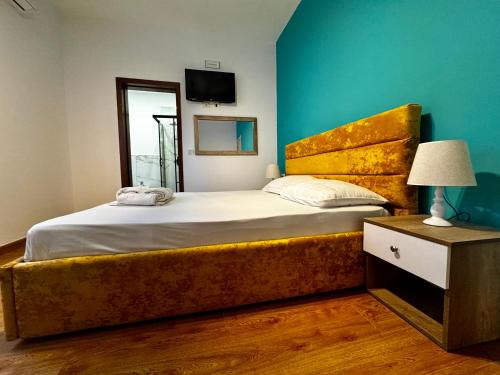 a bedroom with a large bed and a blue wall at Hotel Globo in Durrës