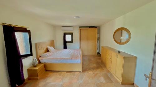 a bedroom with a bed and a dresser and a mirror at Yellow House on the Nile in Luxor